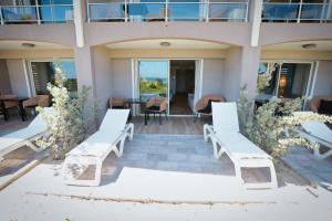 a group of white benches on a patio at Orient Beach Hotel in Orient Bay