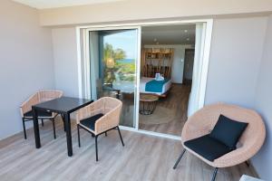 a dining room with a table and chairs and a living room at Orient Beach Hotel in Orient Bay