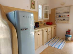a blue refrigerator in a kitchen with wooden cabinets at Simos suites in Elafonisos