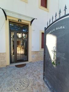 un edificio con una señal delante de una puerta en B&B Villa Sara Falconara, en Licata