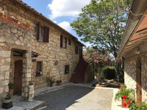 a stone building with a staircase and a tree at Casale Nadia in Sarteano