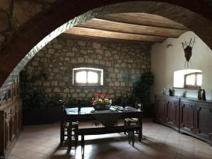 a dining room with a table and a stone wall at Casale Nadia in Sarteano