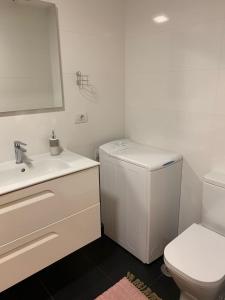 bagno bianco con servizi igienici e lavandino di Vigo centro ciudad, con garaje a Vigo