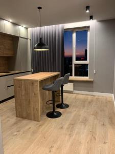 a kitchen with a desk and a chair and a window at Apartment near the airport in Boryspilʼ