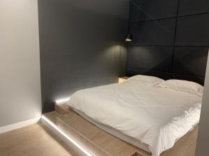 1 dormitorio con cama blanca y cabecero negro en Apartment near the airport en Boryspilʼ