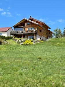 a wooden house on top of a field of grass at Chambre privée au pied des pistes - Chambre chez l'habitant - ChaletNelda com in Lamoura