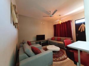 a living room with a couch and a table at Elegant 1 Bedroom Condo Near Vipingo Ridge Golf Resort in Kilifi