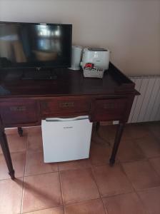 biurko z telewizorem i białym pudełkiem pod nim w obiekcie LA PENSION DE DOÑA ANITA w mieście San Antonio de Requena
