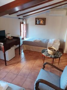 ein Schlafzimmer mit einem Bett, einem Tisch und einem Klavier in der Unterkunft LA PENSION DE DOÑA ANITA in San Antonio de Requena