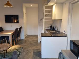 uma cozinha e sala de jantar com um lavatório e uma mesa em De Rokerij em Monnickendam