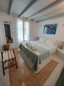 a bedroom with a large bed and a chair at Simos suites in Elafonisos