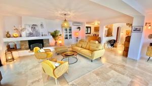 a living room with yellow furniture and a fireplace at Découvrez la Villa « The View » in Cavalaire-sur-Mer