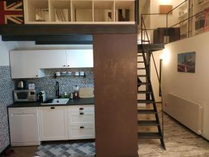 a kitchen with a loft bed and a ladder at La petite maison de Claire in Cuneo