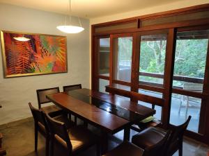 Un comedor con mesa y sillas de madera. en Casa aconchegante em Guaeca - 8 pessoas, en São Sebastião