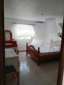 1 dormitorio con 2 camas individuales y ventana en chez arlette, en Petit-Bourg