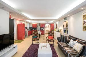 ein Wohnzimmer mit einem Sofa und einem TV sowie eine Küche in der Unterkunft Appartement Indépendant en maison à 15 MIN de LYON in Saint-Symphorien-dʼOzon
