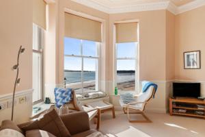 a living room with a view of the ocean at 7 South Beach Court - Sea Front Apartment with Spectacular Sea Views in Tenby