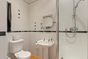 a bathroom with a shower and a toilet and a sink at 7 South Beach Court - Sea Front Apartment with Spectacular Sea Views in Tenby +20 photos