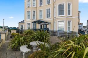 a building with a bench in front of it at 7 South Beach Court - Sea Front Apartment with Spectacular Sea Views in Tenby