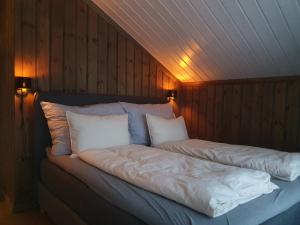 LifjellにあるGrostulのベッド(白いシーツ、枕付)