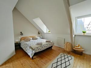 a white bedroom with a bed and a window at My Duplex House Trouville in Trouville-sur-Mer