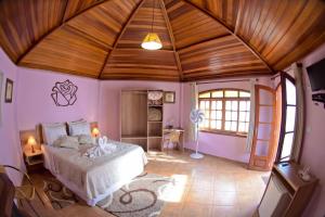 a bedroom with a large bed with a wooden ceiling at Pousada Villa Da Montanha in São Bento do Sapucaí +180 photos