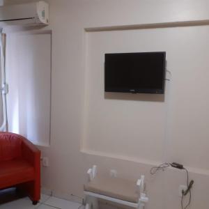 a room with a flat screen tv on a wall at Fronteira Hotel in Santana do Livramento