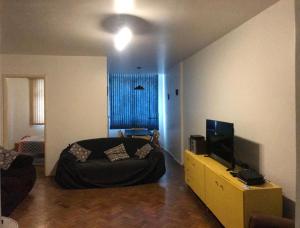1 dormitorio con 1 cama y TV en Apartamento de 3 quartos prox ao Posto 2 - COPACABANA, en Río de Janeiro