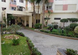 une cour d'un bâtiment avec des arbres et des plantes dans l'établissement Reservyou, à Casablanca
