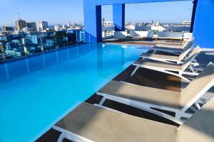a swimming pool with lounge chairs on the roof of a building at Apartamento S1404 Downtown Santo Domingo in Santo Domingo