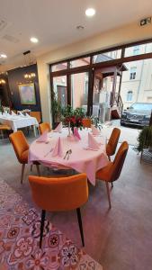 uma sala de jantar com uma mesa rosa e cadeiras em Hotel Siesta em Świebodzin