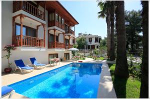a villa with a swimming pool in front of a house at Ayka Hotel in Akyaka