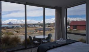 um quarto com uma cama e vista para as montanhas cobertas de neve em Lakeview Studio A - Lake Tekapo em Lake Tekapo