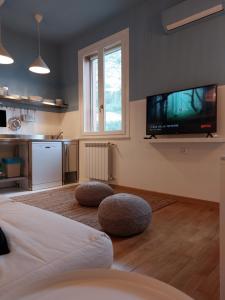 Piazza Mondello Lifestyle Home Palermo في مونديلّو: غرفة معيشة مع تلفزيون بشاشة مسطحة على الحائط