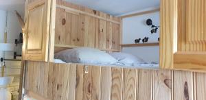un lit dans une armoire en bois avec deux oreillers dans l'établissement Studio Alpheratz Forest - 1 à 3 pers - WIFI, balcon, vue piste et glacier Muzelle, calme, proche commerces et pistes- TSC Super Venosc à 80m, à Les Deux Alpes
