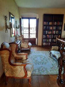 una sala de estar con varias sillas y una alfombra. en Palacio Marqués Vega de Anzo - Villa de campo sXVII, en Siero