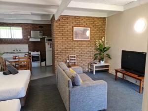 een woonkamer met een bank en een tv bij Motel Wellington Wodonga in Wodonga