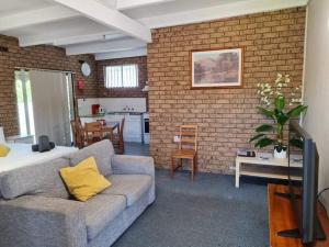 a living room with a couch and a brick wall at Motel Wellington Wodonga in Wodonga