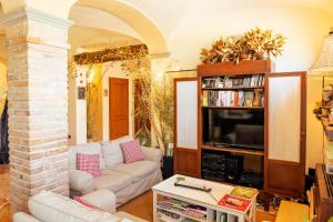 sala de estar con sofá y TV en Agriturismo Cà Nuova, en Minerbio