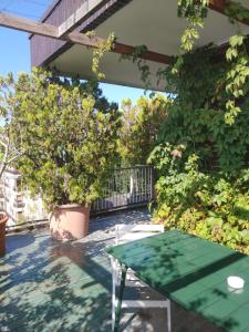 eine Terrasse mit einem grünen Tisch und einigen Pflanzen in der Unterkunft Mita Milano City Life Roof Garden in Mailand