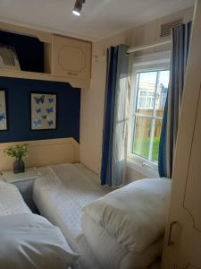een slaapkamer met 2 bedden en een raam bij 6 Berth on Seaview (Fanfare) in Ingoldmells