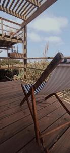 a hammock sitting on a deck near the beach at El Palafito in La Pedrera