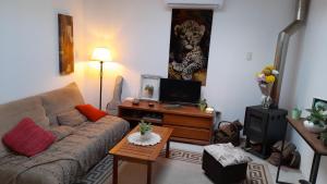 a living room with a couch and a tv at Posada Mela in Colonia del Sacramento