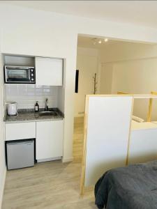 a small kitchen with a sink and a microwave at Monoambiente en el centro de Carlos Paz in Villa Carlos Paz