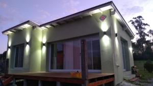 a small green house with a wooden deck at La paz in Tandil