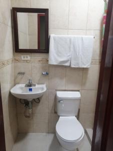 
a white toilet sitting next to a white sink in a bathroom at Hotel Caribbean View in Bocas Town
