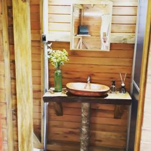 La salle de bains est pourvue d'un lavabo et d'un miroir. dans l'établissement Eco Aldeia, à Nova Petrópolis