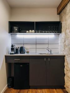 a kitchen with black cabinets and a sink at Triabunna Barracks in Triabunna