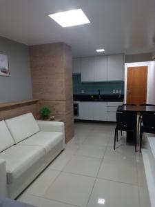 - un salon avec un canapé blanc et une table dans l'établissement Praia dos Carneiros Flat Hotel Apto Completo, à Tamandaré
