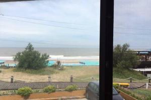 a view of a beach from a window with the ocean at Edificio Playa Villa Gesell in Villa Gesell +7 photos